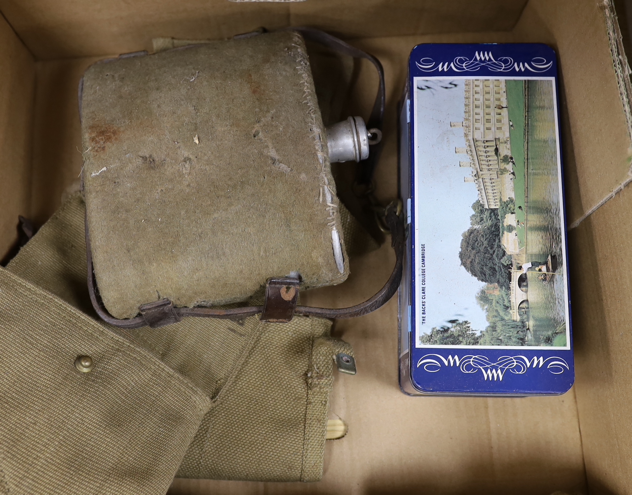 A collection of militaria including a union flag, gunners sight, camouflage webbing, a water bottle, an axe, a bosun’s whistle, and other items